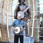 Pete Wernick with the Sir Walter Raleigh statue at World of Bluegrass 2016 - photo © Bill Warren