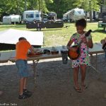 Young pickers checking out the instrument petting zoo at the 2016 Milan Bluegrass Festival - photo © Bill Warren