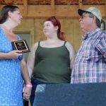 Michael Adams' widow and his granddaughter accept his SMBMA Hall of Honor induction at the 2016 Milan Bluegrass Festival - photo © Bill Warren