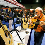 Doyle Lawson tests a new Martin at IBMA 2011 - photo © Dean Hoffmeyer
