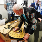 Doyle Lawson autographing guitars at ICM for charity - photo by Sherri George