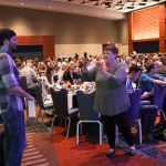 Katy Daley photographs her colleague Brad Kolodner with his Momentum Award at World of Bluegrass 2016 - photo by Frank Baker