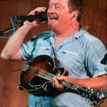 Lou Reid with Seldom Scene calls Ben Eldridge from the stage at the August Gettysburg Bluegrass Festival - photo by Frank Baker