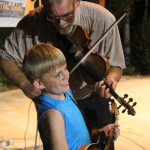 Johnny Ridge tirtures his grandson with his fiddle at the Bass Mountain Boys reunion at the 2016 Pickin' By The Lake Festival - photo by Laura Tate Photography