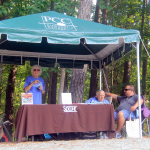 Little covered merch tent on the hill at the 2016 Pickin' By The Lake Festival - photo by Laura Tate Photography