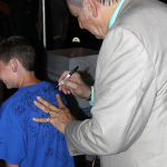 Del McCoury signs a young fan's shirt at the 2015 Red, White & Bluegrass Festival - photo © Laura Tate Photography