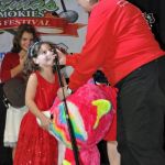 Lorraine Jordan gives a rainbow bear to Caroline Williamson at the 2016 Christmas in the Smokies festival in Pigeon Forge, TN - photo © Bill Warren