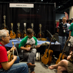 Tony Williamson, Scott Napier, and Lauren Price jam in the Mandolin Central booth at the 2016 World of Bluegrass - photo by Tara Linhardt
