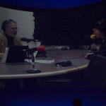 Tara in a radio interview about Mountain Music Project. Photo taken of the large screen in the Natural Science museum for the show The State of Things at World of Bluegrass 2015 - photo © Tara Linhardt
