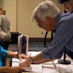 Hall of Fame members Tom Gray and Jesse McReynolds signing Hall of Fame book at Wide Open Bluegrass 2016 - photo © Tara Linhardt