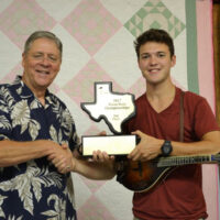 Texas Mandolin Champion for 2017 Sam Armstrong accepts his trophy from Arvin Holland with BABA - photo by Tina Boatwright