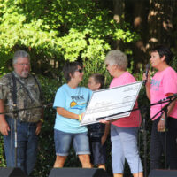 Patti Clayon presents the first check for the Blake Johnson scholarship at the 2017 Pickin' By The Lake festival - photo by Laura Tate Photography