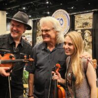 Mark O'Connor, Ricky Skaggs, and Maggie O'Connor in the Exhibit hall at the 2017 IBMA Wide Open Bluegrass festival - photo by Frank Baker