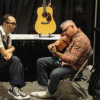 Kenny Smith checks out a guitar in the Exhibit hall at the 2017 IBMA Wide Open Bluegrass festival - photo by Frank Baker
