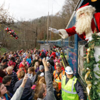 Santa throwing presents into the crowd from the Santa Train - photo by Ed Rode (2018)