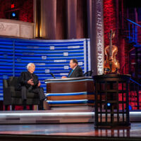 Lamar Peek talks about the Roy Acuff fiddle with Mike Huckabee at Trinity Broadcasting Network - photo courtesy of TBN