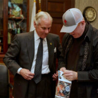 Todd Taylor autographs a CD for Governor Henry MacMaster of South Carolina in his office (May 2, 2018)