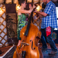 Zoe Guigueno and Worth Dixon changing strings at the 2018 Grey Fox Bluegrass Festival - photo © Tara Linhardt