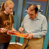 Bobby Osborne signs a mandolin for a student at the 2018 Bobby Osborne Mandolin Roundup - photo by Terry Vaught