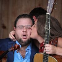 Sally Berry plants a kiss on her husband, Hunter, at the August 2018 Gettysburg Bluegrass Festival - photo by Frank Baker