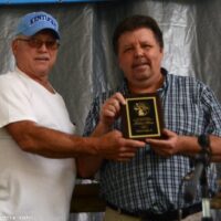 Ron Benton presents Hall of Fame plaque to Dana Cupp, Jr at the 2018 Blissfield Bluegrass on the River - photo © Bill Warren