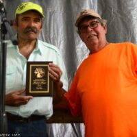 Tim Ellis accepts Hall of Fame plaque from Bill Warren at the 2018 Blissfield Bluegrass on the River - photo © Bill Warren