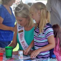 Haley Petrowski, Miss River Raisin 2018, helps out at the Kid's Corner at the 2018 Blissfield Bluegrass on the River - photo © Bill Warren