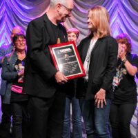 Christopher Howard-Williams accepts his Distinguished Achievement Award from Alison Brown at the 2018 IBMA Special Awards - photo © Frank Baker
