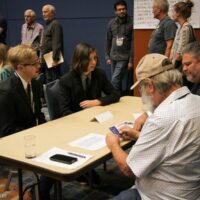 Cane Mill Road talks to promoters at the 2018 World of Bluegrass - photo © Frank Baker