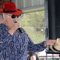 MC Jo Odom with Les Sears' hat at the 2019 Florida Bluegrass Classic - photo © Bill Warren