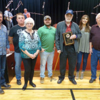 Family and friends of Alan Perdue following the presentation of an annual award started in his memory: (l-r) Kevin Richardson (friend), Sandy Perdue (brother), Janice Perdue (mother), Chris Perdue (son), Bobby Franklin (recipient of the first annual Alan Perdue Memorial Bluegrass Appreciation Award), Tabatha Perdue (daughter), and Ardle Lee Perdue (father).