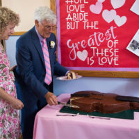 Tom Gray and Barb Diederich cut their bass-shaped cake at their wedding reception (5/11/19) - photo © Tara Linhardt