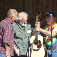 Presentation of the prize winning guitar at the 2019 Wayne Henderson Festival (l-r) Herb Key-director of the guitar competition, Jesse Smith-2019 winner, and Wayne Henderson, event coordinator and festival namesake - photo by Sandy Hatley
