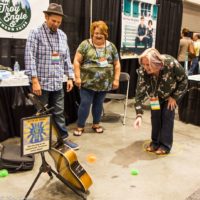 Lisa Kay Howard plays "soundhole" at Troy Engle's booth during World of Bluegrass 2019 - photo © Tara Linhardt