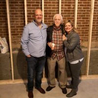 Chris Smith, J.D. Crowe, and Missy Smith standing where the old Red Slipper Lounge stage had once stood at Bluegrass in the Bluegrass in Lexington, KY