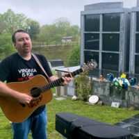Ralph Stanley II sings at the gravesite of his father and his uncle Carter - photo by Tayloe Emery