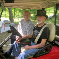 Chuck Langley (driver's seat), founder and producer of the festival, along with Dan Daniels, President of the SouthEastern Bluegrass Association at the 2019 Armuchee Bluegrass Festival