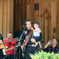 Taylor Malpass introduces his son, John, at the 2021 Willow Oak Park Bluegrass Festival - photo by Laura Ridge