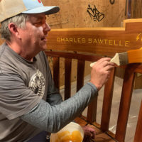 Scott Dailey applying fin fish to the restored Charles Sawtelle Memorial Bench