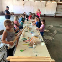 Kids making craft banjos at the 2021 Marshall Bluegrass Festival - photo by Chris Smith