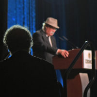 Lee Michael Demsey watches as Dudley Connell introduces him at the IBMA Industry Awards - photo © Bill Reaves