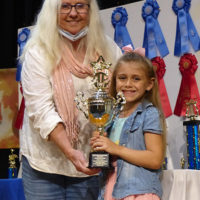 Vivian Pennington Hopkins presents 7-year-old Anna Parker with the Don and Margaret Livengood Memorial Award for outstanding youth performance at the 2021 Granite Quarry Fiddlers' Convention in Salisbury, NC - photo by Gary Hatley