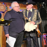 David Harvey with Gibson presents Doyle Lawson with a signed mandolin back in honor of his retirement (11/27/21) - photo by Styx Hicks