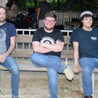 Aaron Ramsey, Troy Boone, and Jacob Burleson hold ng down a bench at the 50th annual Charlotte Bluegrass Festival - photo © Bill Warren