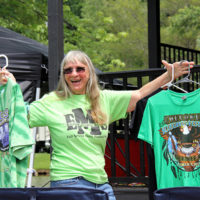 Debi Evans hawking shirts at the 2022 Cherokee Bluegrass Festival - photo by Laura Tate Photography