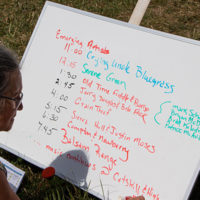The Creekside Stage Friday stage schedule being posted at the 2022 Grey Fox Bluegrass Festival - photo © Tara Linhardt