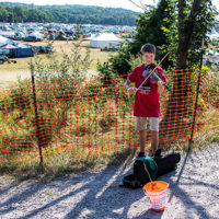 Young fiddler busking for money for the Bluegrass Kids Academy at the 2022 Grey Fox Bluegrass Festival - photo © Tara Linhardt