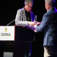 Chris Jones accepts his Broadcaster of the Year award at the 2022 IBMA Industry Awards luncheon - photo © Frank Baker