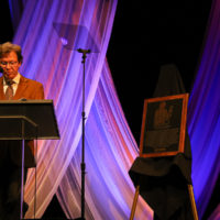 Dan Hayes presents the story of Paul "Moon" Mullins during his Bluegrass Music Hall of Fame induction - photo © Frank Baker