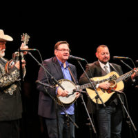 Doyle Lawson, Joe Mullins, and Adam McIntosh play in tribute to Paul "Moon" Mullins during his Bluegrass Music Hall of Fame induction - photo © Frank Baker